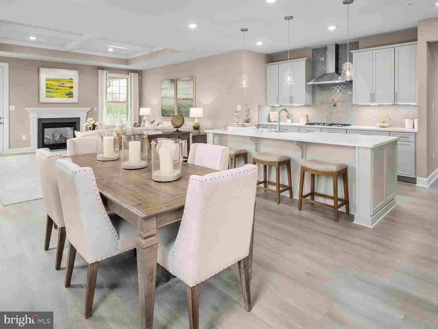 6558 Stream Song Court Columbia, MD 21044 - Photo 5 of 20 a dining room with kitchen island furniture a wooden floor and a fireplace