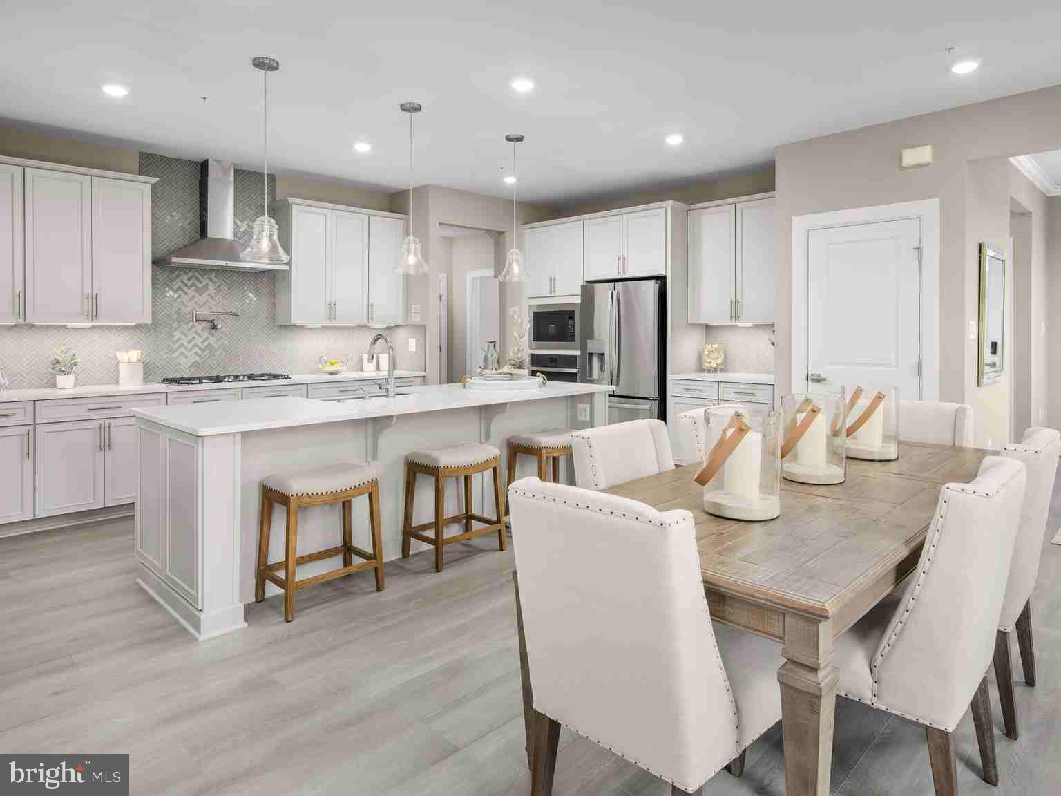 6558 Stream Song Court Columbia, MD 21044 - Photo 6 of 20 a kitchen with stainless steel appliances granite countertop a dining table chairs refrigerator microwave and cabinets