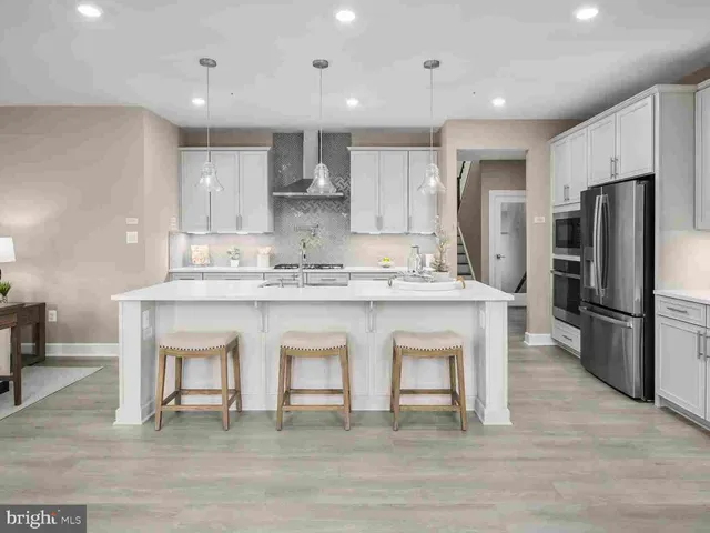 a kitchen with stainless steel appliances granite countertop a white cabinets and wooden floor