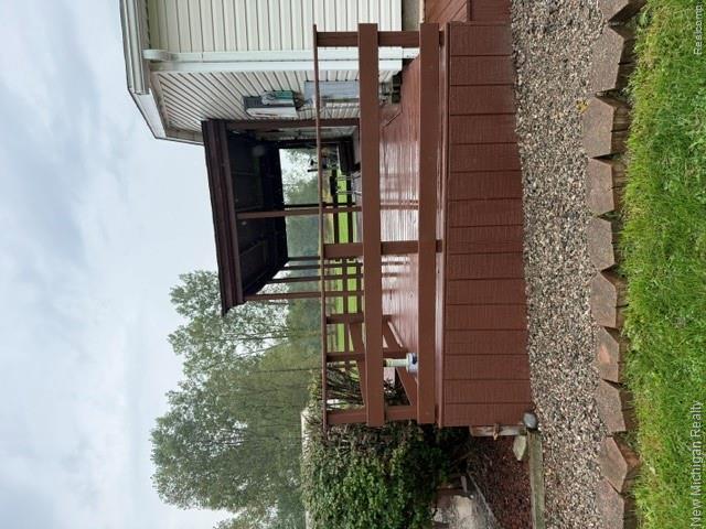 Expansive outdoor deck with a covered portion, wood railing, and a gravel border