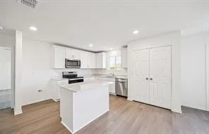 a kitchen with stainless steel appliances a refrigerator sink and microwave