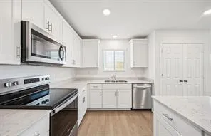 a kitchen with stainless steel appliances granite countertop a stove a sink and a microwave