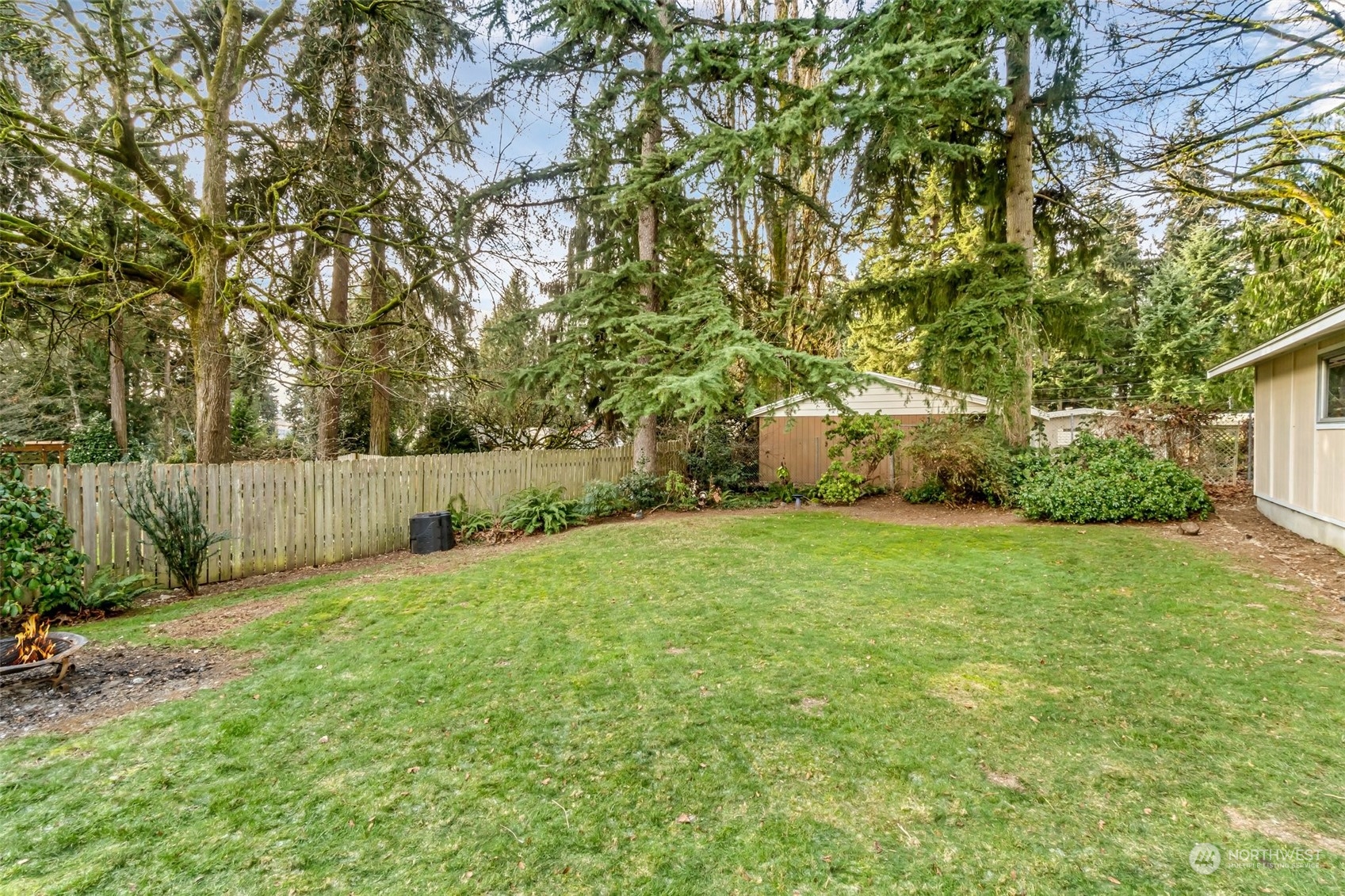 24204 2nd Place West Bothell, WA 98021 - Photo 27 of 34 a backyard of a house with plants and large trees