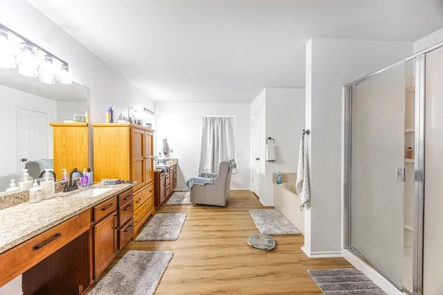 a spacious bathroom with a double vanity sink a large mirror and a shower