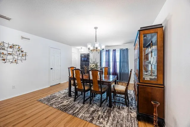 a dining room with furniture a chandelier and wooden floor