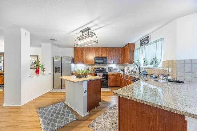 a kitchen with stainless steel appliances granite countertop a sink stove and refrigerator