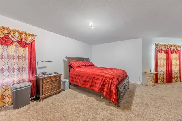 a spacious bedroom with a bed and a cabinets