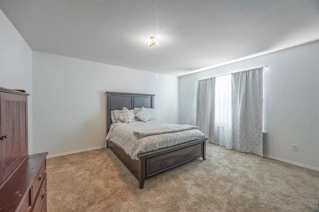 a white bed sitting in a room next to a window
