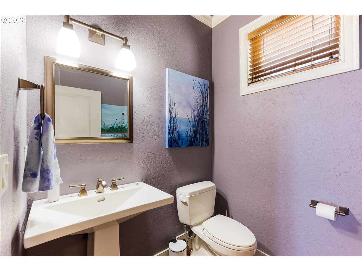 6643 Northwest Meridian Ridge Drive Portland, OR 97210 - Photo 13 of 48 a bathroom with a toilet a sink and mirror
