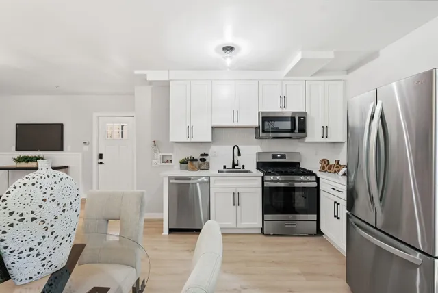 a kitchen with stainless steel appliances a stove a sink and a refrigerator