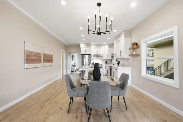 a view of a dining room with furniture a chandelier and wooden floor