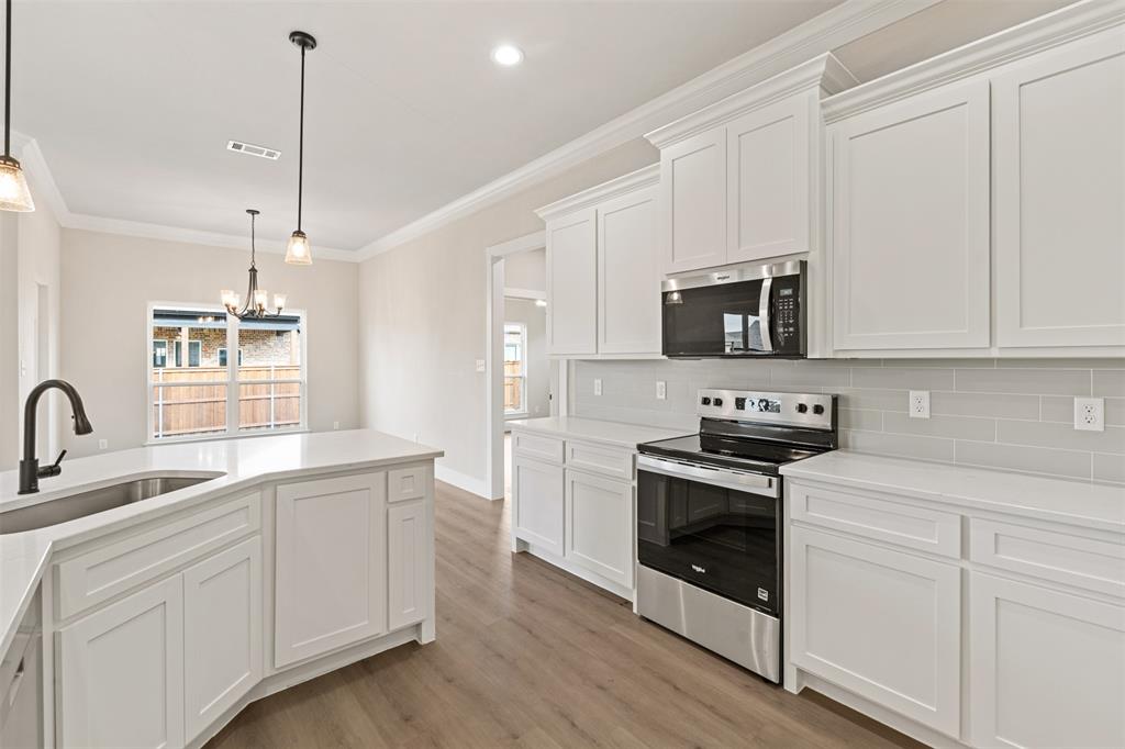 506 Limestone Circle Mabank, TX 75147 - Photo 10 of 33 a kitchen with white cabinets and stainless steel appliances