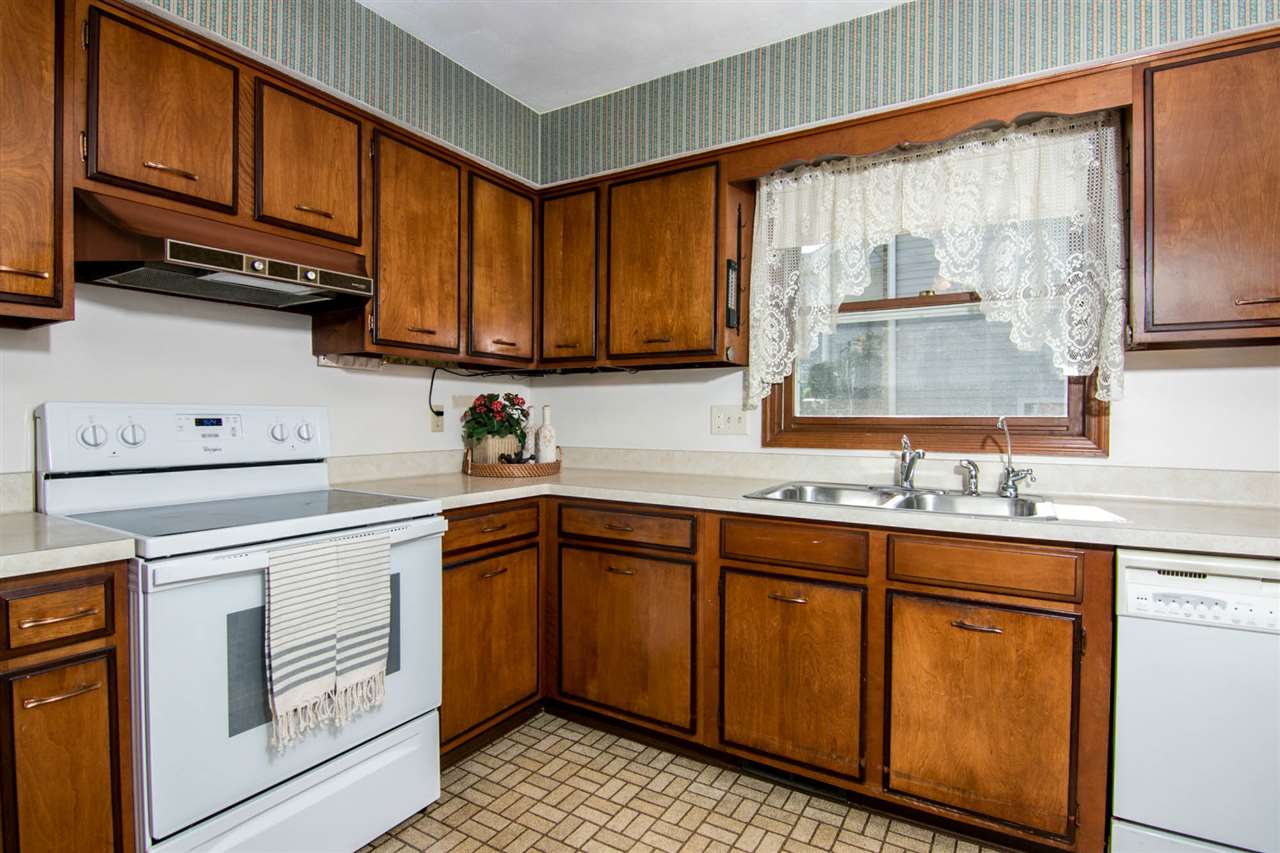 4861 Welsh Road Rockford, IL 61107 - Photo 8 of 21 a kitchen with stainless steel appliances granite countertop a sink a stove and cabinets with wooden floor
