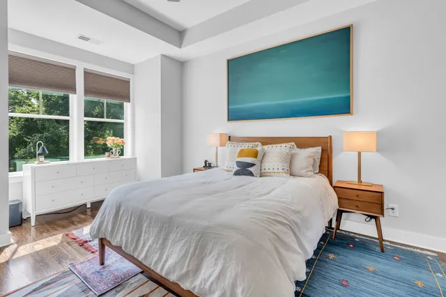 a bedroom with a bed and a flat tv screen on dresser