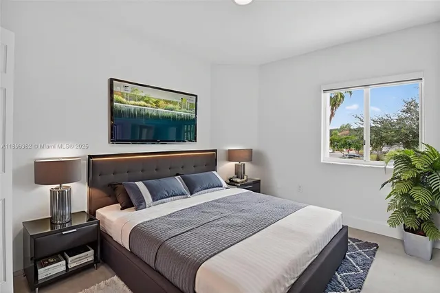 a bedroom with a bed and a potted plant