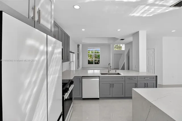 a kitchen with a sink a refrigerator and cabinets