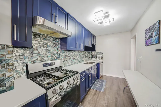 a kitchen with a stove and wooden cabinets