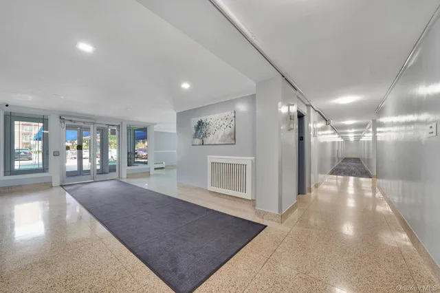 a view of a hallway with wooden floor and a living room