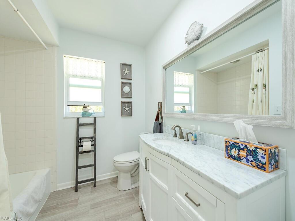 226 Torrey Pines Point Naples, FL 34113 - Photo 17 of 27 Full bath featuring baseboards, toilet, vanity, and shower / bathtub combination with curtain