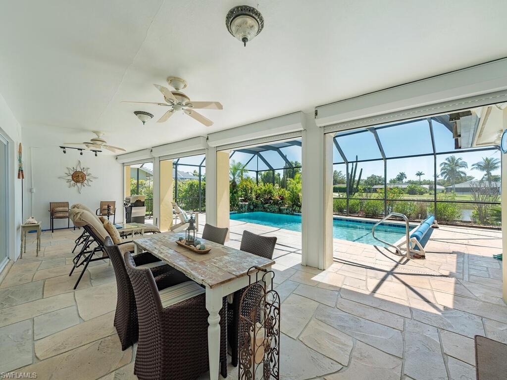 226 Torrey Pines Point Naples, FL 34113 - Photo 23 of 27 View of patio featuring glass enclosure, outdoor dining area, an outdoor pool, and ceiling fan
