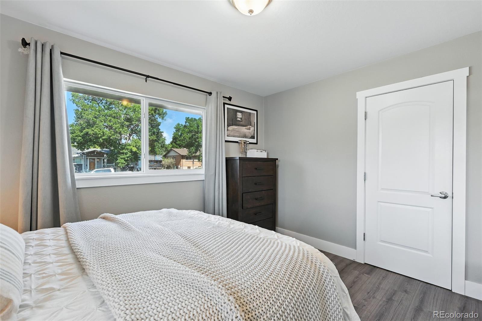 2714 South Raleigh Street Denver, CO 80236 - Photo 15 of 34 a bedroom with a bed and a large window