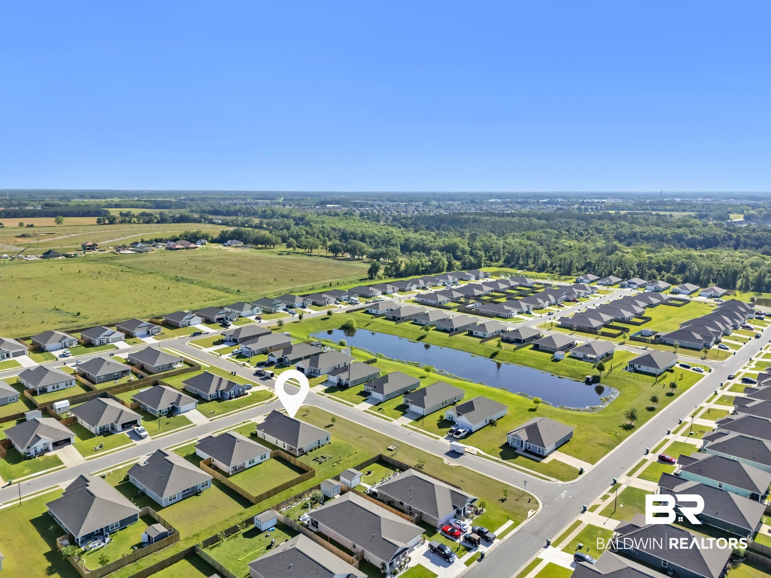 1228 Caper Avenue Foley, AL 36535 - Photo 53 of 54 Aerial view of a residential community featuring a prominent retention pond and surrounding green spaces