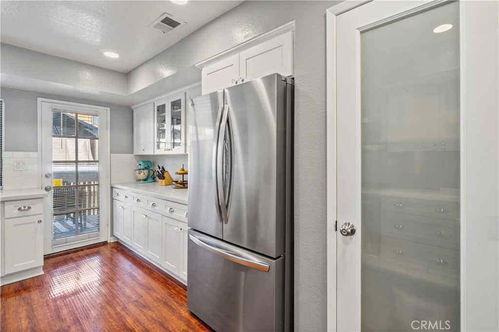 8520 Lake Knoll Avenue, Unit B Garden Grove, CA 92844 - Photo 11 of 31 a kitchen with stainless steel appliances a refrigerator and a wooden floor