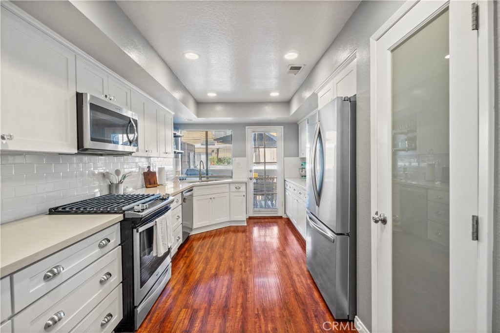8520 Lake Knoll Avenue, Unit B Garden Grove, CA 92844 - Photo 9 of 31 a kitchen with granite countertop stainless steel appliances cabinets a sink and a wooden floor