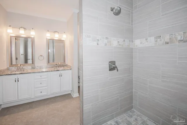 a bathroom with a granite countertop sink two mirror and shower