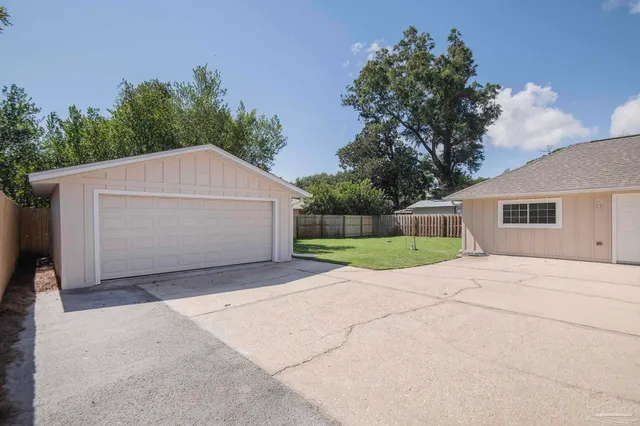 a view of backyard of house and garage