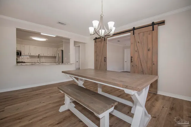 a room with wooden floor and chandelier