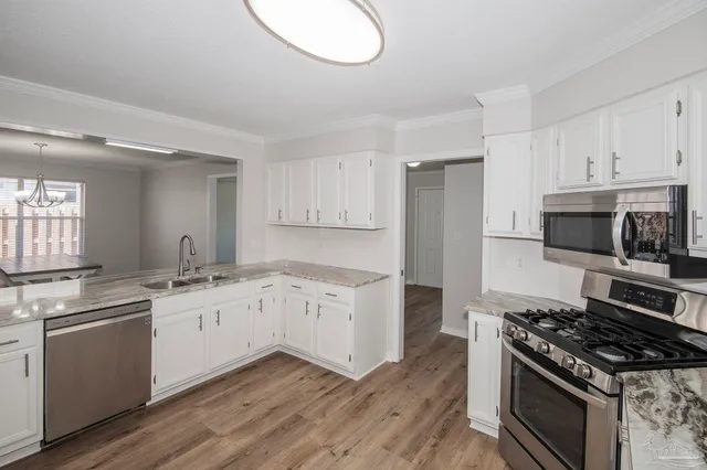 a kitchen with granite countertop a sink and a stove top oven