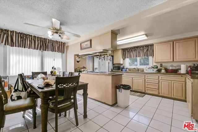 a kitchen with a dining table chairs and white cabinets