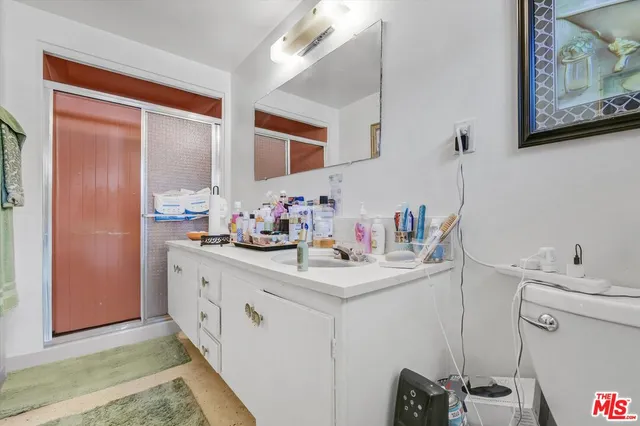 a bathroom with a sink a toilet and shower