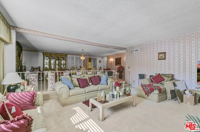 a living room with furniture and a view of bedroom