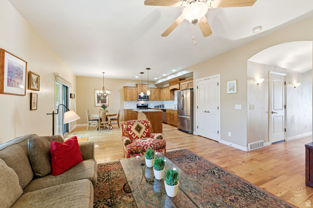 7235 Viansa Court Midvale, UT 84047 - Photo 7 of 43 Living room with light wood-type flooring, a ceiling fan, hanging lights, and arched walkways