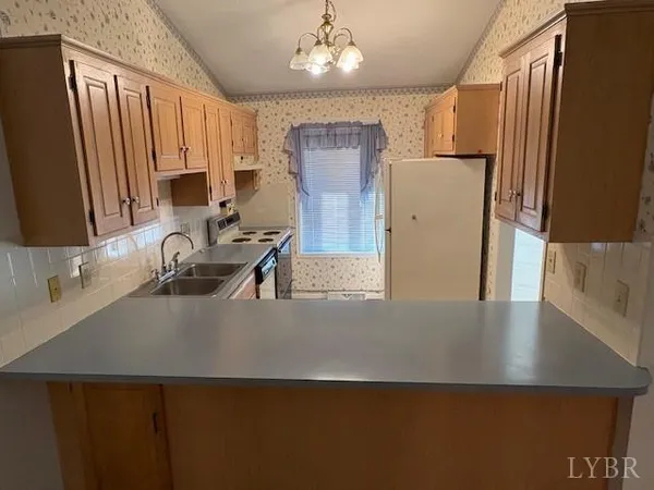 a close view of a sink a refrigerator and a dishwasher in a kitchen