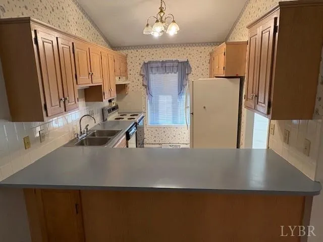 a close view of a sink a refrigerator and a dishwasher in a kitchen