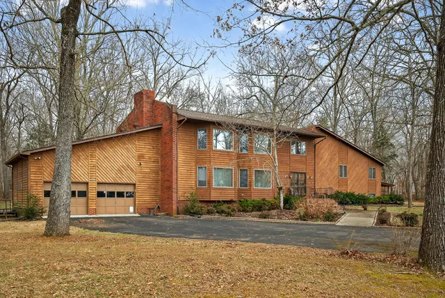 a view of a house with a yard covered in snow
