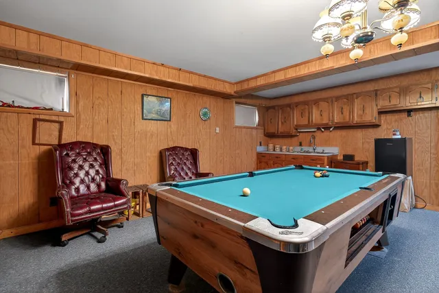 a room with pool table and windows