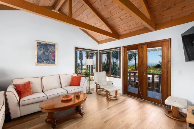 a living room with furniture a flat screen tv and a large window