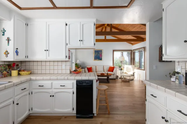 a kitchen with white cabinets and sink