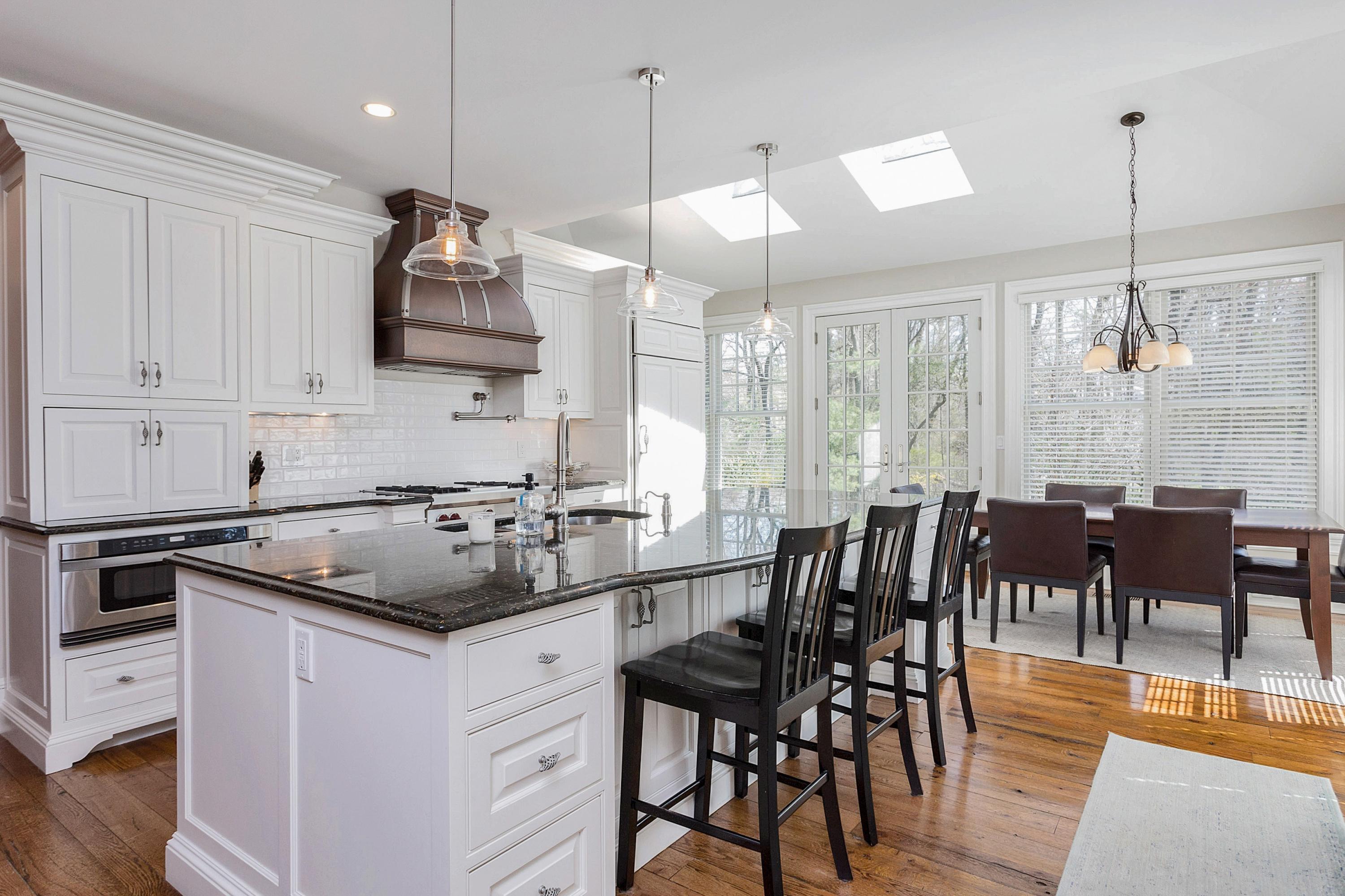 5 Old Parish Road Darien, CT 06820 - Photo 12 of 40 a kitchen that has a lot of cabinets in it with stainless steel appliances granite countertop a stove a sink a dining table and chairs with wooden floor
