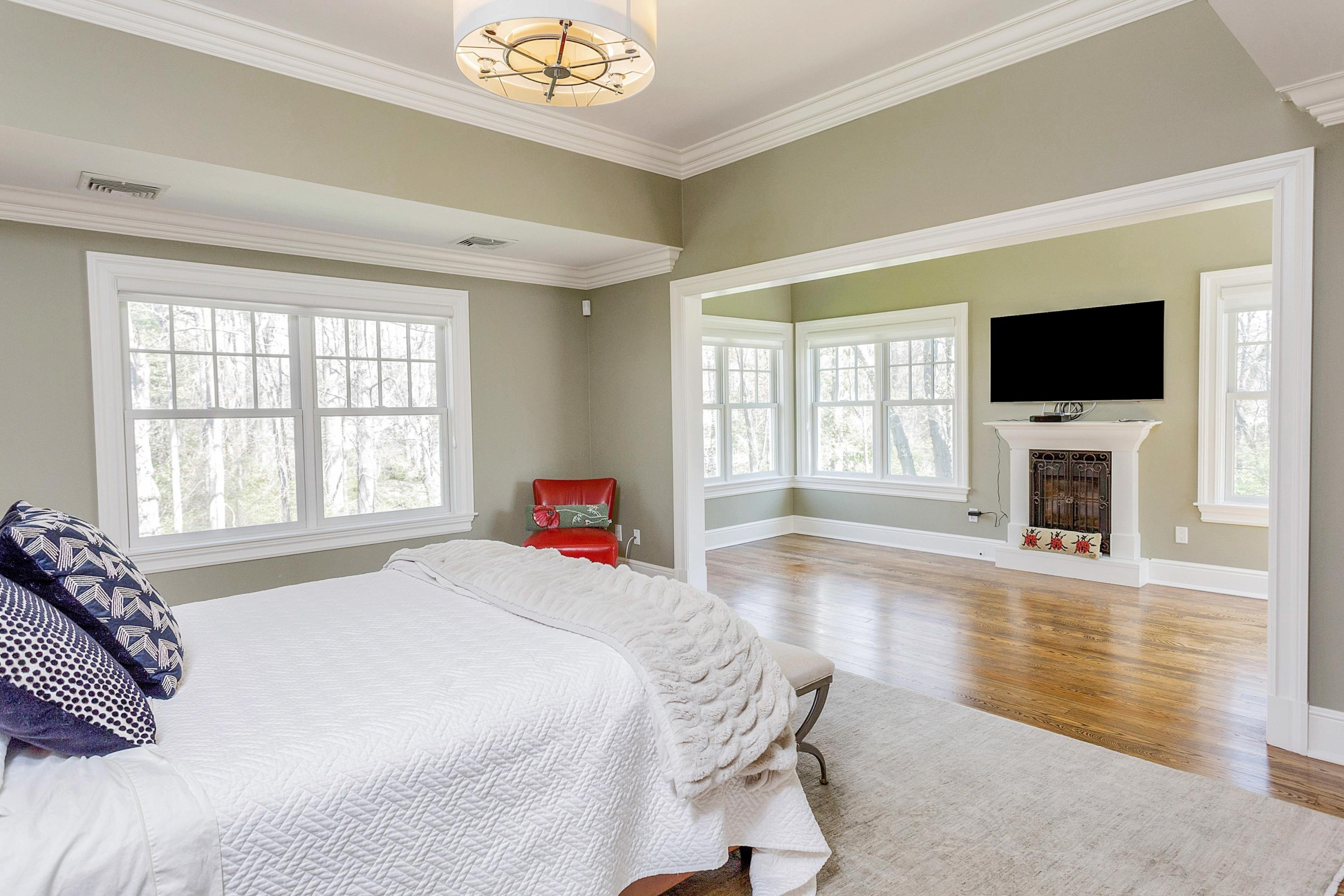 5 Old Parish Road Darien, CT 06820 - Photo 25 of 40 a spacious bedroom with a bed and a flat screen tv