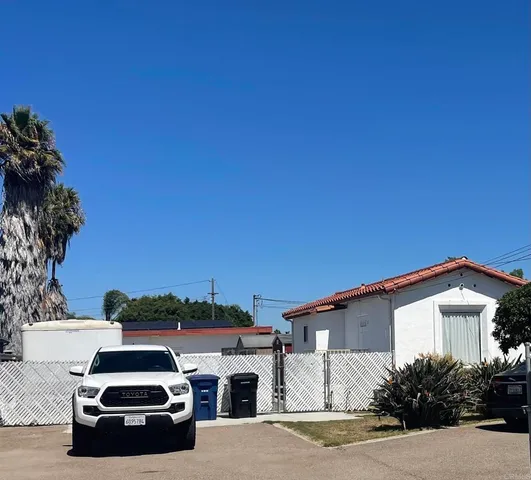 a car parked in front of white house with a small yard