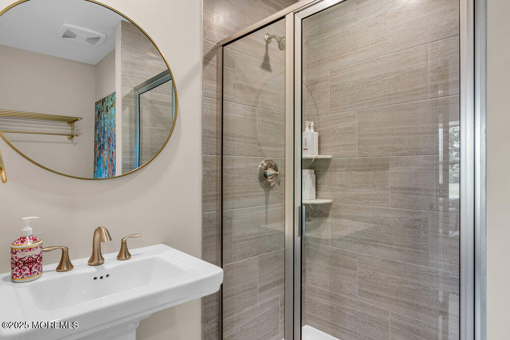 63 Bataan Avenue Tinton Falls, NJ 07724 - Photo 11 of 64 a bathroom with a sink a mirror a vanity and shower