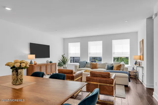 a kitchen with stainless steel appliances granite countertop a sink a stove a refrigerator cabinets and chairs