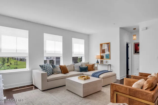 a kitchen with stainless steel appliances kitchen island granite countertop a refrigerator a stove a sink a dining table and chairs with wooden floor