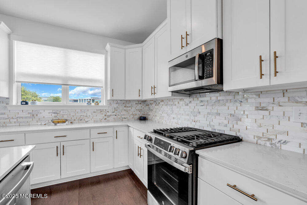 63 Bataan Avenue Tinton Falls, NJ 07724 - Photo 22 of 64 a kitchen with granite countertop white cabinets stainless steel appliances and a sink