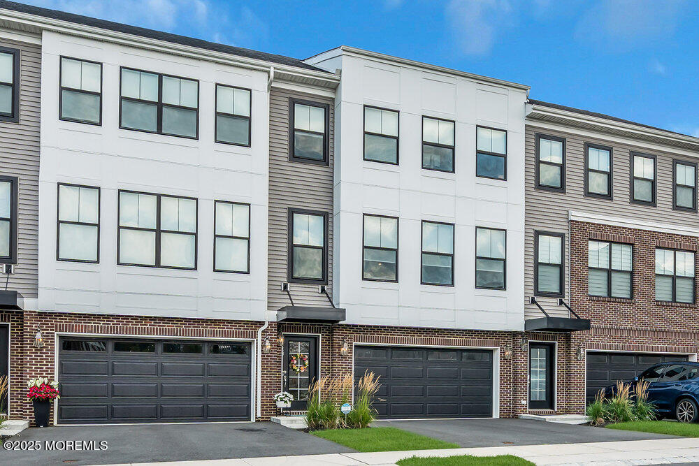 63 Bataan Avenue Tinton Falls, NJ 07724 - Photo 4 of 64 a front view of a brick house with many windows